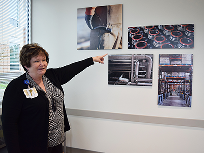 Wanda Fletcher, R.N., clinic manager shows some of the photographs on display at the new Hilborn Road occupational health building.